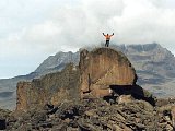 Eg klatra opp på ei klippe utanfor Kibo Hut. Mawenzi i bakgrunnen.